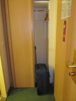 Closet with right half open, suitcase in the entry to show the width