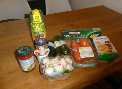 Tomato juice, spaghetti sauce, pesto sauce, yogurt, mushrooms, squash, cucumber, tomatoes, spaghetti, and packaged cookies.