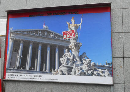 Austrian government building with a “For Sale” sign on a statue.