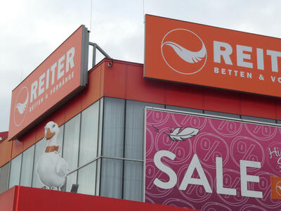 Front of a bedding store with a large cartoonish duck on the roof