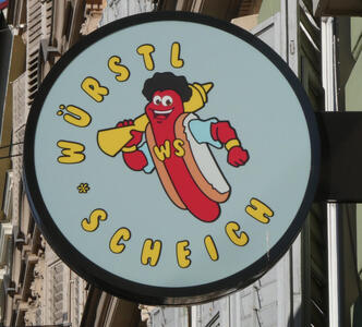 Logo for Würstl Schiech: cartoon hot dog with black hair and blue shirt, carrying a mustard bottle on his shoulder.