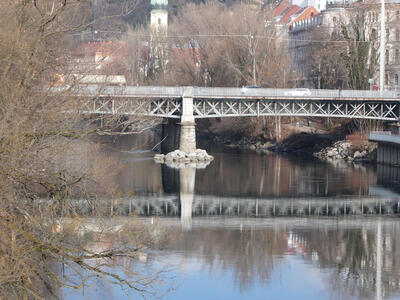 Reflection of a bridge in the Mur river