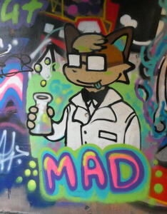 Fox with square glasses and lab coat; text MAD underneath the drawing