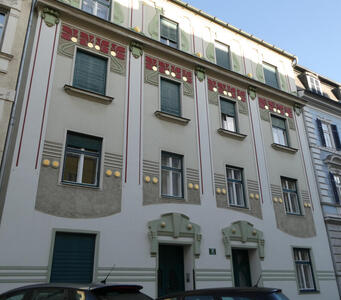 Building façade with colored dots and wavy borders painted on it.