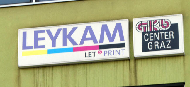 Sign for Leykam printer with color bars in order yellow, cyan, magenta, and black.