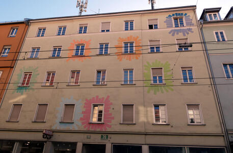 Building with multi-colored “splashes” of paint around some of the windows