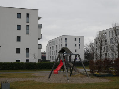 white apartment block with childrens playground slide