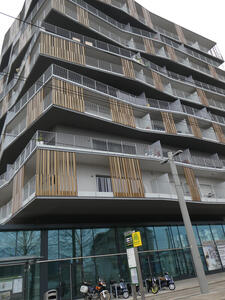 Apartment with multiple  thin vertical bronze strips on balconies