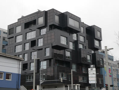 Irregularly spaced black cubes protruding from building.