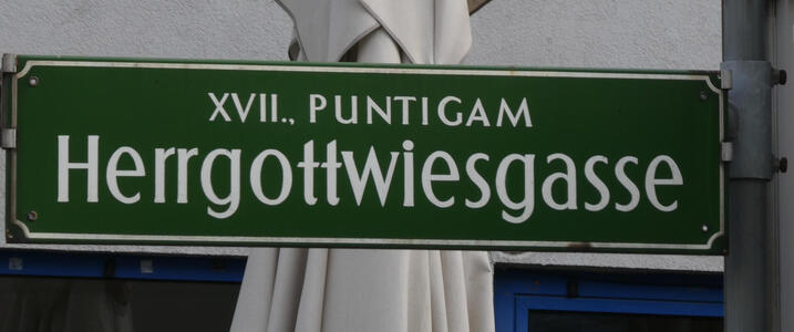 Street sign Herrgottwiesgasse; the letters seem out of proportion and are badly kerned.