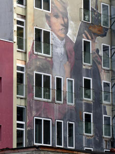 Multi-story wall painting of blond-haired boy with brown dog