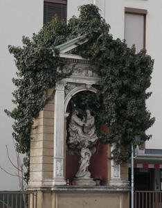 statue in plant covered niche