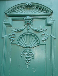 Turquoise door with relief of demonic-looking head