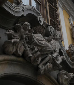 Bearded man in clerical garb, holding cross, surrounded by cherubs