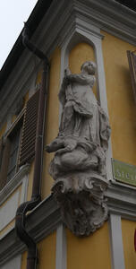 Woman with hands folded in prayer, head tilted, smiling