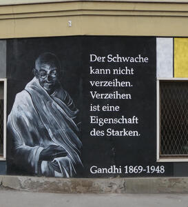 Painting of Gandhi with text „Der Schwache kann nicht verzeihen. Zerzeihen ist eine Eigenschaft des Starken.“