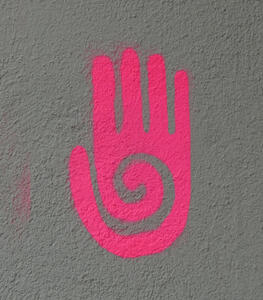 Graffiti of open hand, painted with pink spray paint