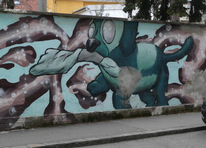 Wall painting of a green dog holding a marijuana cigarette in its mouth as if it were a stick.