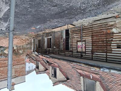 dilapidated building with sections of roof falling off