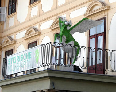 winged green cow on balcony