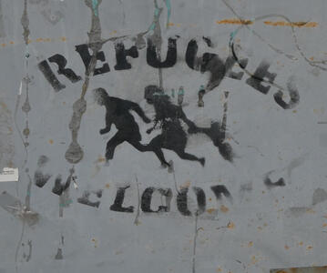 Silhouettes of running family with words “Refugees Welcome”