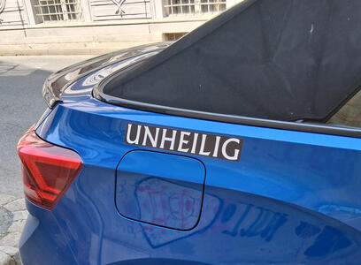 Blue car with decal UNHEILIG over the gas cap door