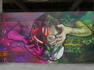 Two hands holding a gas mask with a head in it.