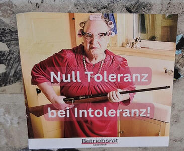 Angry woman in red dress and curlers, carrying a rifle: „Null Toleranz bei Intoleranz!“