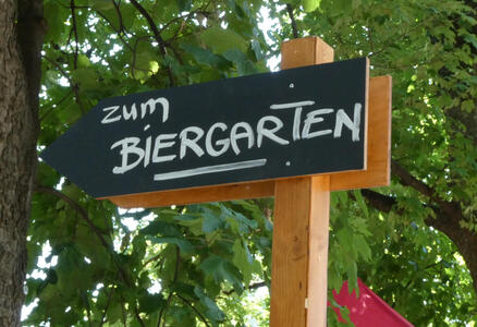 Sign in shape of arrow with text „zum Biergarten“.