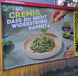 So cremig, dass du nicht widerstehen kannst.  Picture of bowl of pasta with pesto flavoring. In the background is a jar of Barilla pesto.
