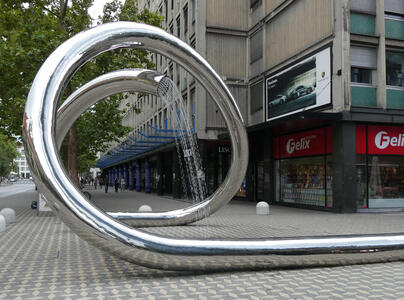 Long, large aluminum pipe that curves around several times before ending in a shower.