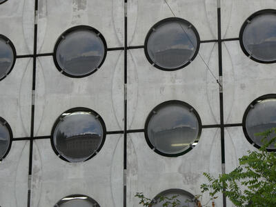 building reflected in array of round windows