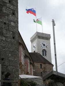 Castle clock tower with flags of Slovenia and Ljubljana