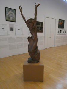 sculpture of kneeling person with arms upraised