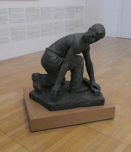 sculpture of young man on one knee looking to side