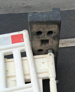 Traffic barrier on its side. The brick looks like a surprised face with an open mouth.
