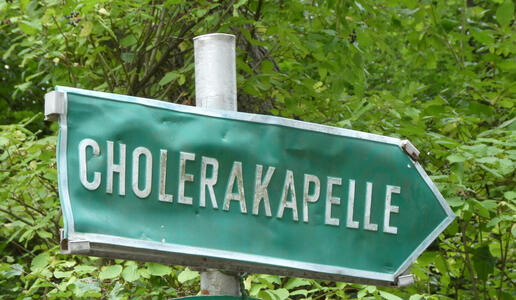 Green sign in shape of arrow with text CHOLERAKAPELLE