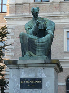 Statue of J.J. Strossmayer; he is seated with one hand on his knee. He has hair like the pointy-haired boss in Dilbert.