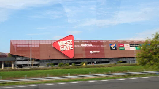 Shopping mall with triangular sign with text WEST GATE
