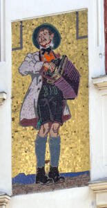 Mosaic of man in lederhosen and bow tie with white overcoat, playing an accordion