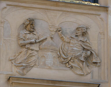 Reliefwork of two men. One is holding a cup in an upraised hand; the other is using some sort of tool (perhaps a baker)