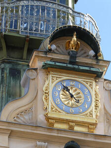 Clock at top of glockenspiel. Above it, a golden bird