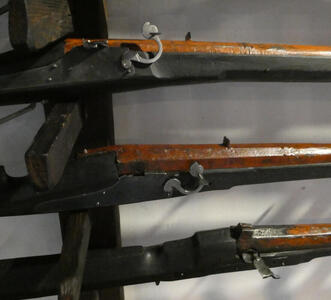 closeup of rifle showing metalwork near the butt end of the barrel.