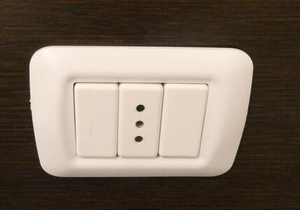Italian wall socket with three holes in a line