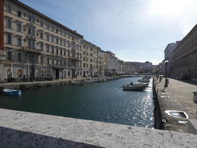 The grand canal in Trieste; boats are at the side of the canal.