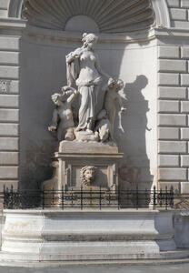 Statue of woman with a child. A lion’s head is carved on the base of the sculpture.