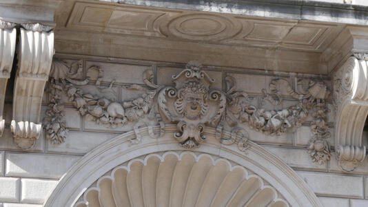 Intricate reliefwork of various plants. In center, a bearded man with fruits and vegetables in his hair