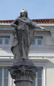 Statue of bearded man in cloak, gesturing downwards