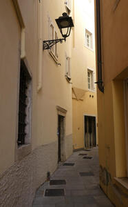 Narrow curving street; walls are painted yellow.