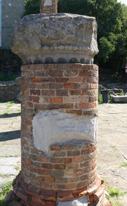 Brick cylinder with the top of a roman column on top of the cylinder